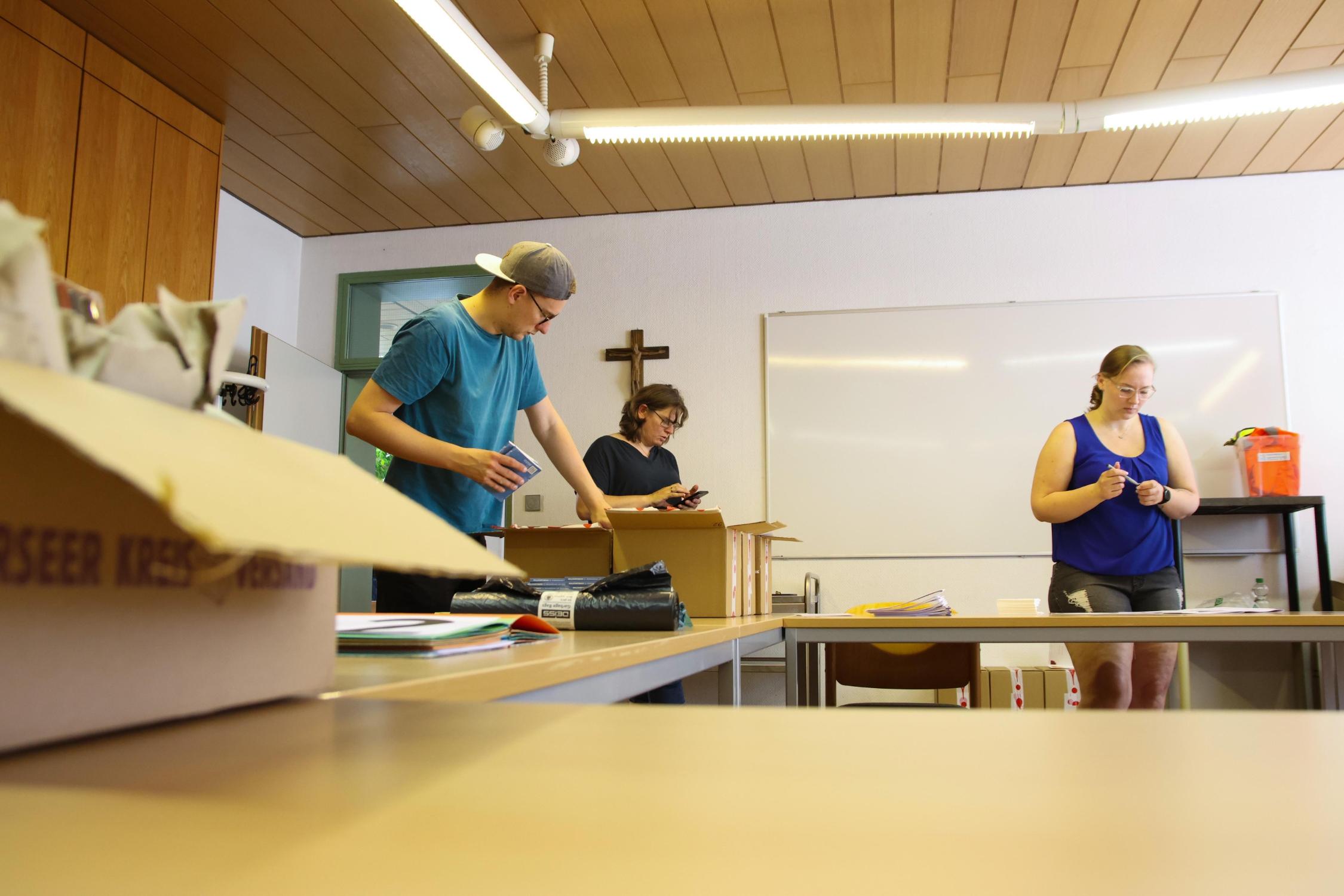 Die Steuerungsgruppe packt Pilgerpakete für die teilnehmenden Ministrantinnen und Ministranten (v.l.): Marco Hullin, Anja Baumer-Löw und Theresa Pfister.