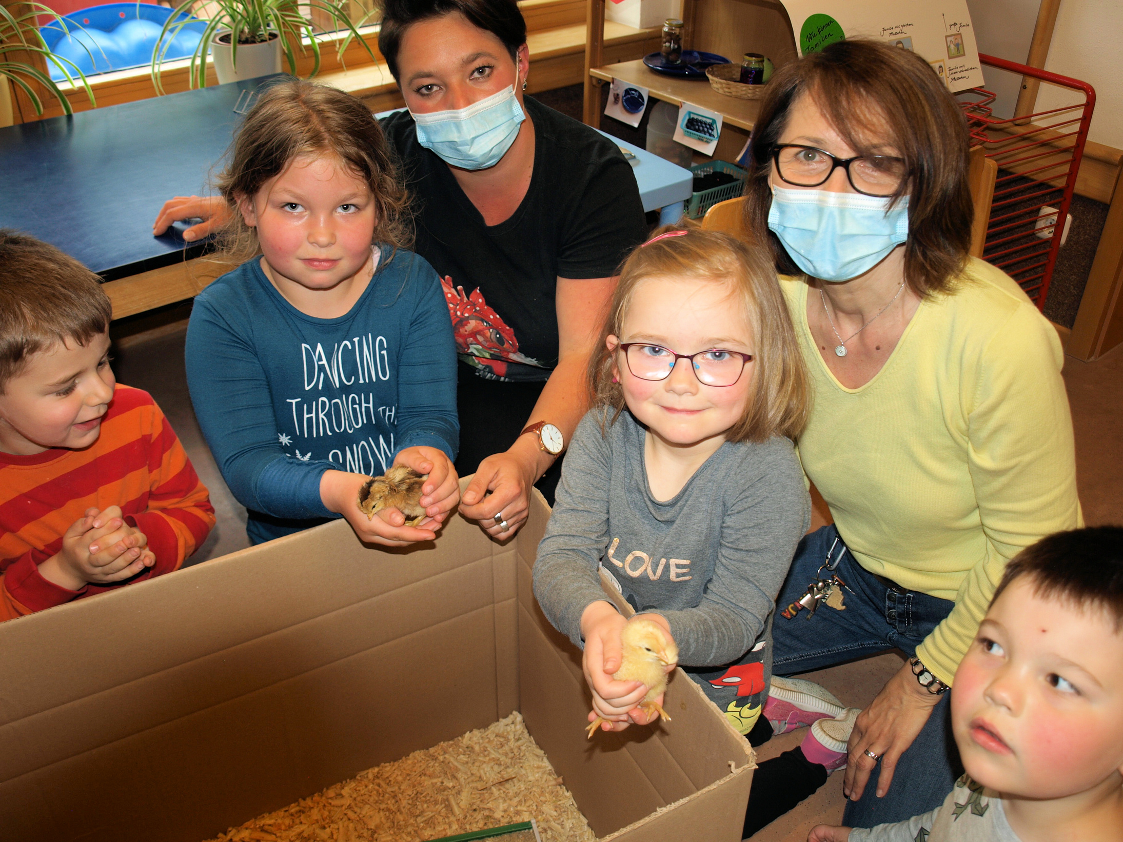 Ganz flauschig fühlen sich die Küken in der Hand an. Hinten links Christin Müller und rechts Tanja Emrich