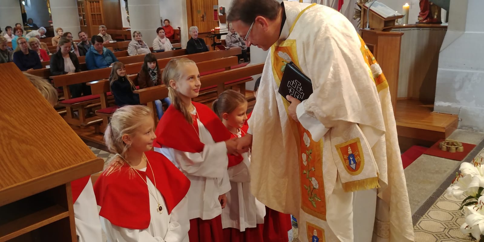 Pfarrer Reis beglückwünscht die neuen Ministranten zu ihrem Dienst
